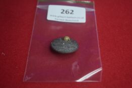 Circular Metal Commemorative Badge “Februar” – A small circular pressed metal badge with raised