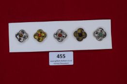 A German WWII WHW set of five pressed-metal flower form badges with coloured centres. Mounted on