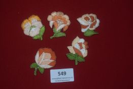 Five WHW embroidered flower badges, various designs in orange, white, and green thread.
