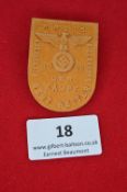 A 1939 German Day Badge, pressed orange card stock with embossed eagle and swastika over “Der
