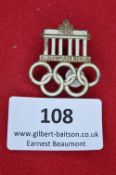 A 1936 Berlin Olympic Games commemorative badge, brass and enamel issue, featuring the Brandenburg