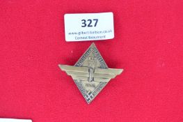 Metal Day Badge – A pressed metal diamond-shaped badge with extended winged motif. Obverse inscribed