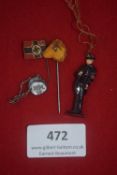 A group of four German WWII WHW day badges, comprising: a small swastika flag stickpin, an amber-