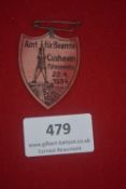 A German political cardboard day badge, shield form, red printed with beacon tower design and