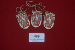 Three postwar German cardboard day badges, shield form, printed with national flags and inscribed “
