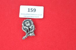 A German Third Reich Tinnie badge in the form of a rose, die-stamped metal construction with