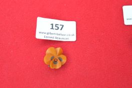 A German Bakelite flower badge, carved amber-coloured plastic pansy with painted detailing, fitted