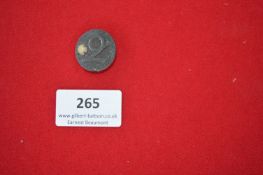 Circular Metal Commemorative Badge “Januar” – A circular pressed metal badge featuring the raised