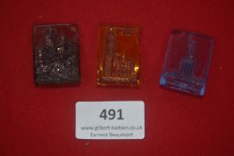 Three German WWII WHW coloured glass day badges, rectangular form with raised designs of buildings