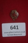 Small badge with clip fastener, depicting a crowned red eagle with spread wings over a wreath