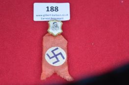 German Third Reich era commemorative ribbon badge, red cloth with swastika motif on roundel,