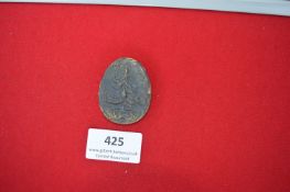 Pressed Metal Day Badge – An oval pressed metal badge depicting a pine tree, inscribed “3.11.35”,