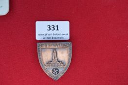 Metal Commemorative Badge – A shield-shaped pressed bronze badge with raised depiction of the