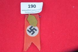 German Third Reich era rally badge, red swallowtail ribbon with white roundel and black swastika,