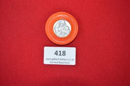 Plastic Fundraising Badge with Religious Medallic Insert – A circular orange plastic badge with