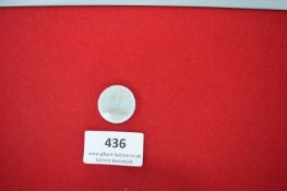 Glass Badge – A small translucent white glass badge, oval-shaped, featuring a finely moulded