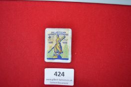 Commemorative Cloth Badge – A rectangular cloth and celluloid badge, printed in colour with a figure