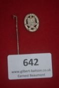 Miniature silvered stickpin badge, oval-shaped with laurel wreath border, central motif of crossed