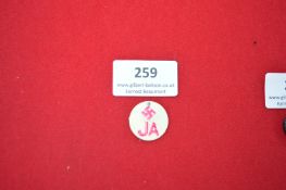 Propaganda Celluloid Badge “JA” with Swastika – A circular white celluloid badge printed with a