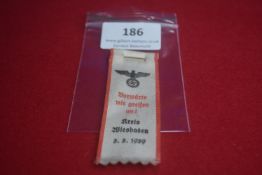 Nazi-era political rally ribbon badge, white cloth printed with eagle/swastika and slogan “