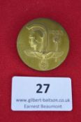 A German National Day badge 1933, circular gilt-finished alloy issue with helmeted head and