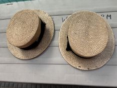 Two straw boaters with black ribbon