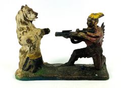An early 20th century cast iron Native American bear hunter coin bank