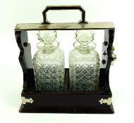 A 1920's mahogany twin decanter tantalus with silver plated fittings