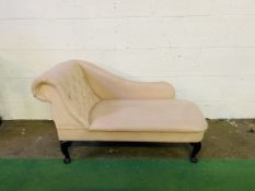 A small upholstered boudoir chaise lounge