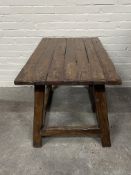 A rustic Spanish style plank top hardwood table with trestle ends