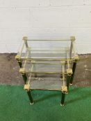 A contemporary brass framed set of three decorative nesting tables