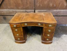 A mahogany reverse serpentine shaped pedestal desk