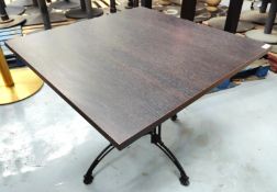 1 x Contemporary Restaurant Table Featuring a Dark Grained Wooden Top and an Ornate Pedestal