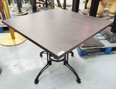 1 x Contemporary Restaurant Table Featuring a Dark Grained Wooden Top and an Ornate Pedestal