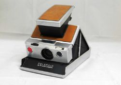 A Polaroid SX-70 Land Camera, with brown body