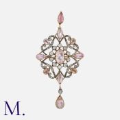 A Pink Topaz And Diamond Brooch Pendant in yellow gold and silver, of scrolling openwork form. Set