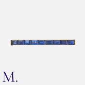 CARTIER. A Vintage Sapphire Brooch in 18K yellow gold, set with nine baguette cut sapphires of