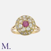 A Ruby And Diamond Ring in yellow gold, comprising a cushion cut ruby within a border of rose cut