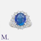A 4.13 Carat Burma No Heat Sapphire And Diamond Cluster Ring in platinum, set with a central oval