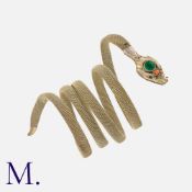 An Antique Snake Bracelet in silver mesh, the head set with an emerald to the head with coral accent