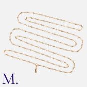 An Antique 9K Gold Long Guard Chain with alternating fancy and trombone links culminating in a dog