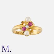 A Diamond, Ruby And Pearl Ring in 18k yellow gold set with an old cut diamond, flanked either side