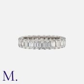 An Emerald Cut Diamond Eternity Ring in platinum, set throughout with a row of emerald cut