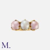 A Pearl Three Stone Ring in yellow gold, set with a white pearl to the centre, flanked either side