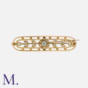 A Gemstone and Pearl Brooch in yellow metal, set with a blue gemstone to the centre of a floral