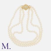 A Three Row Pearl Necklace in 18k yellow gold. Comprising three strands of pearls measuring from 6.