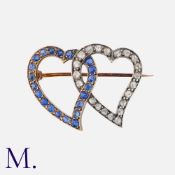An Antique Sapphire and Diamond Witch Heart Brooch in yellow gold and silver, with two entwined