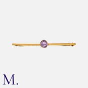 An Amethyst Bar Brooch in 9K yellow gold set with a round cut amethyst. Stamped '9ct' and tests
