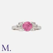 A Pink Sapphire And Diamond Ring in white gold, set with a round cut pink sapphire accented by
