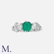 An Art Deco Emerald And Diamond Three Stone Ring in 18k white gold. Set with an emerald of